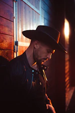 Man in a shearling leather jacket, illuminated by soft, warm lighting that highlights texture.