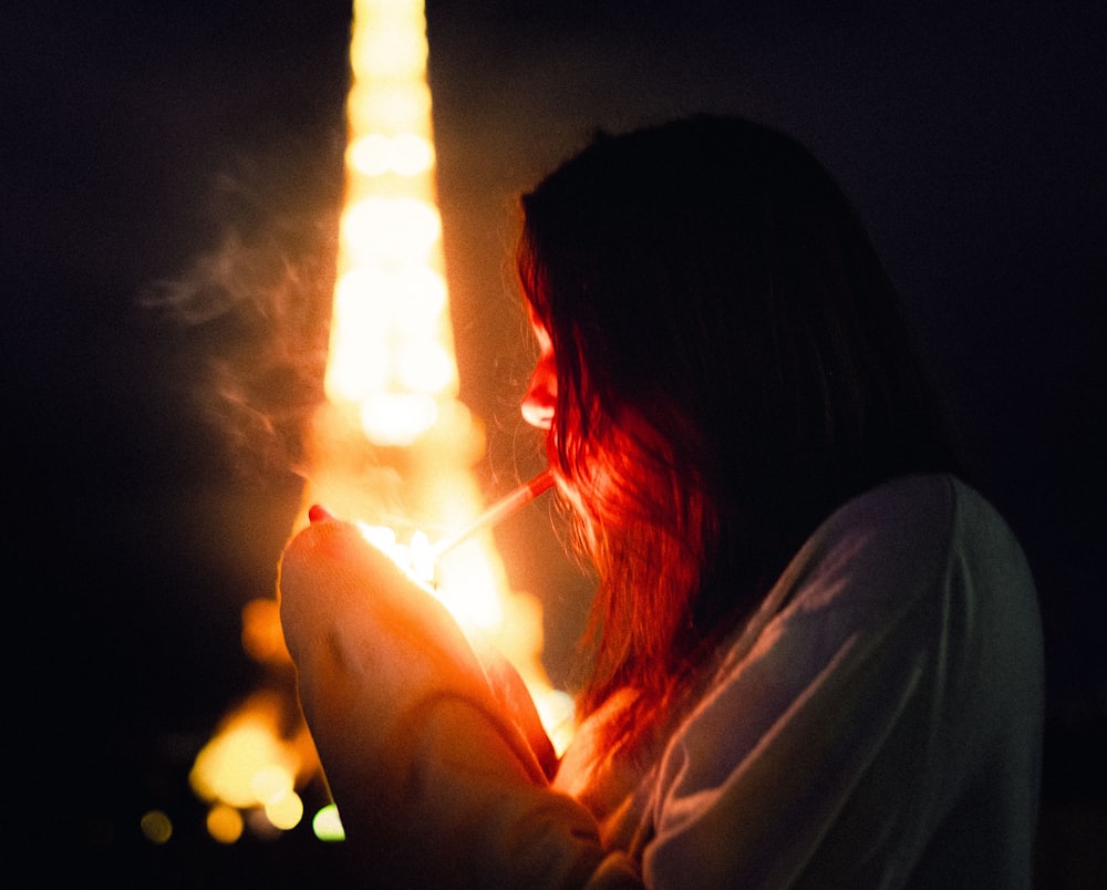 woman holding lighted candle during night time