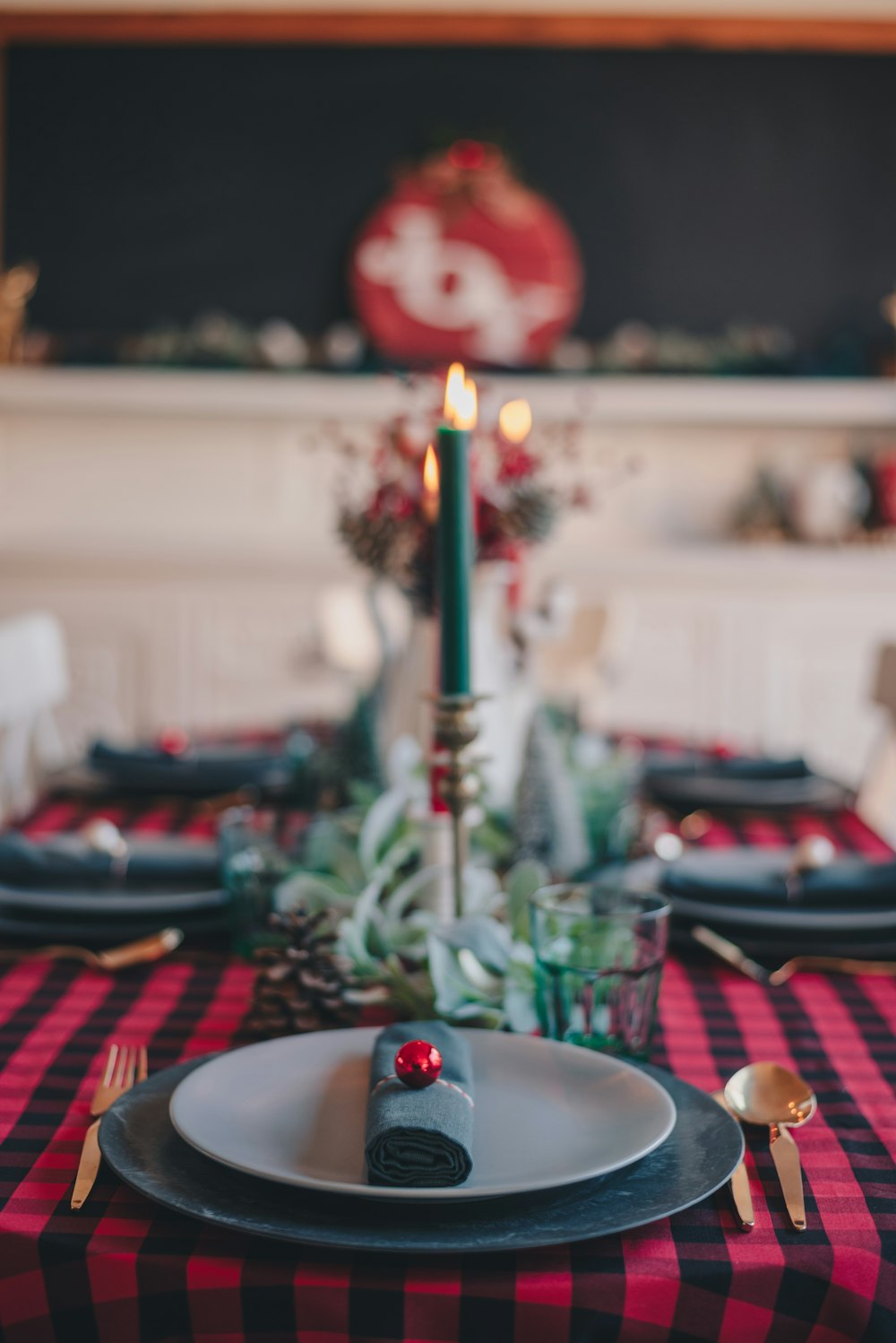 lighted candle on red and white checkered table cloth