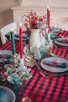 A festive table setting featuring a vibrant red tablecloth and matching napkins.