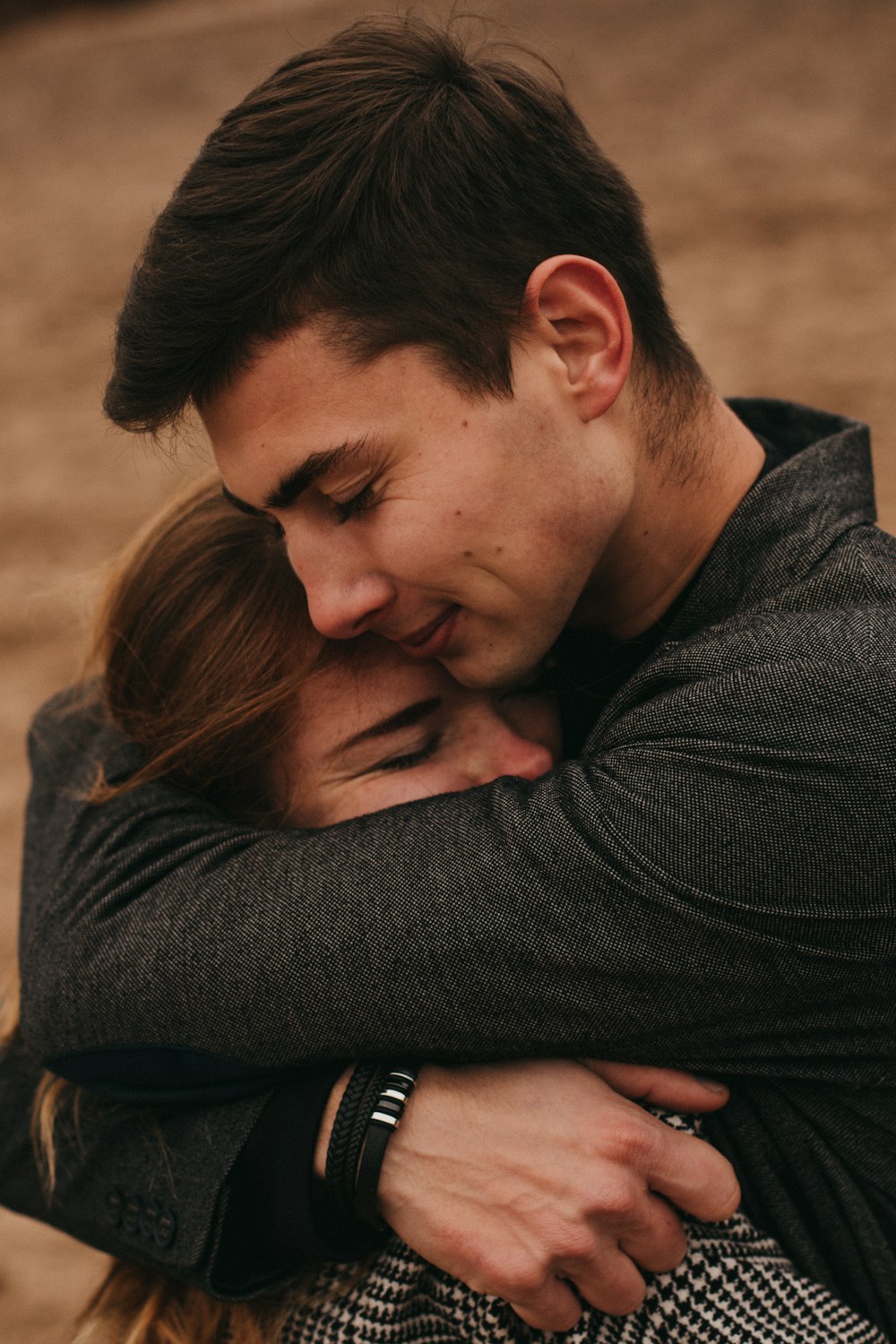 man in black long sleeve shirt hugging woman in black long sleeve shirt