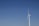 A modern wind turbine with a sleek, bladeless design against a clear sky.