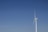 A modern wind turbine with a sleek, bladeless design against a clear sky.