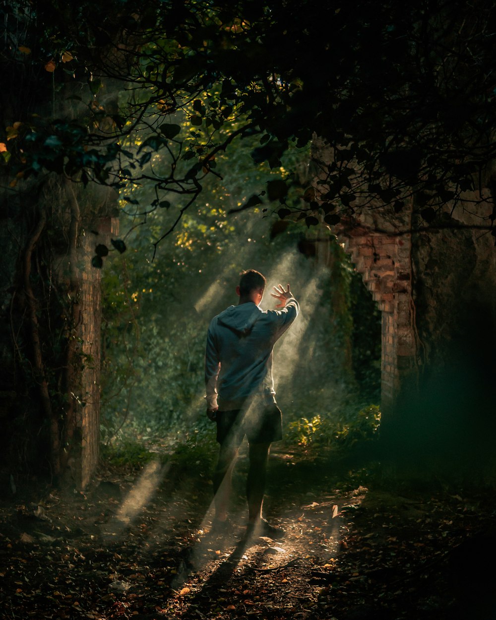 man in blue jacket and gray pants walking on pathway