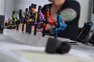 A vibrant tattoo machine in action with ink and needles visible.