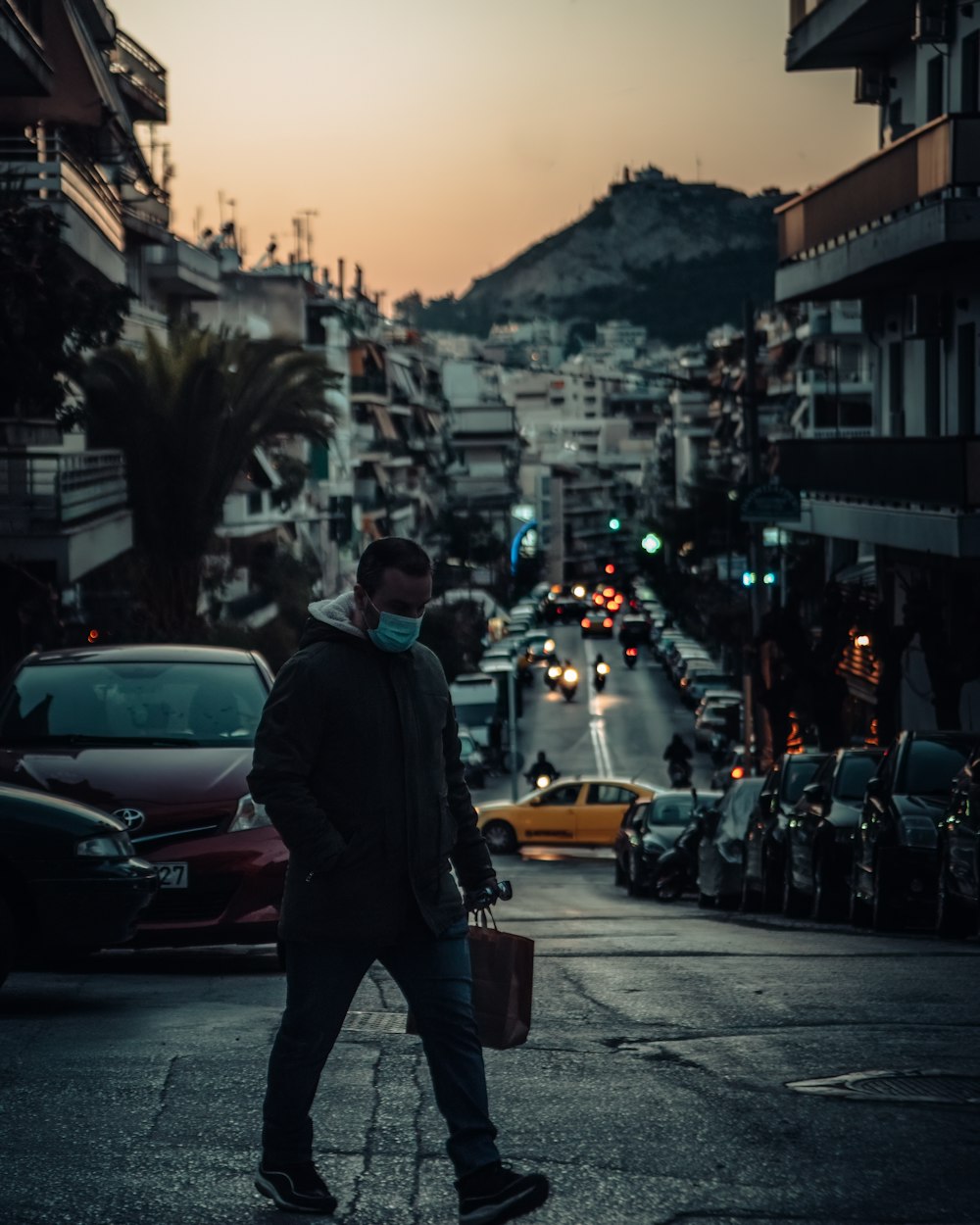 man in black jacket walking on sidewalk during daytime