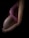 Side profile of a pregnant woman wearing a pink top, gently cradling her belly with one hand. The image is dimly lit, highlighting the curves and contours of the belly, with visible stretch marks.