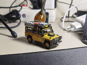 A consultant reviewing digital asset presentations on a laptop surrounded by model vehicles and equipment.