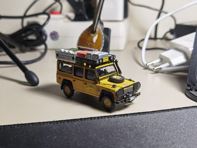A consultant reviewing digital asset presentations on a laptop surrounded by model vehicles and equipment.