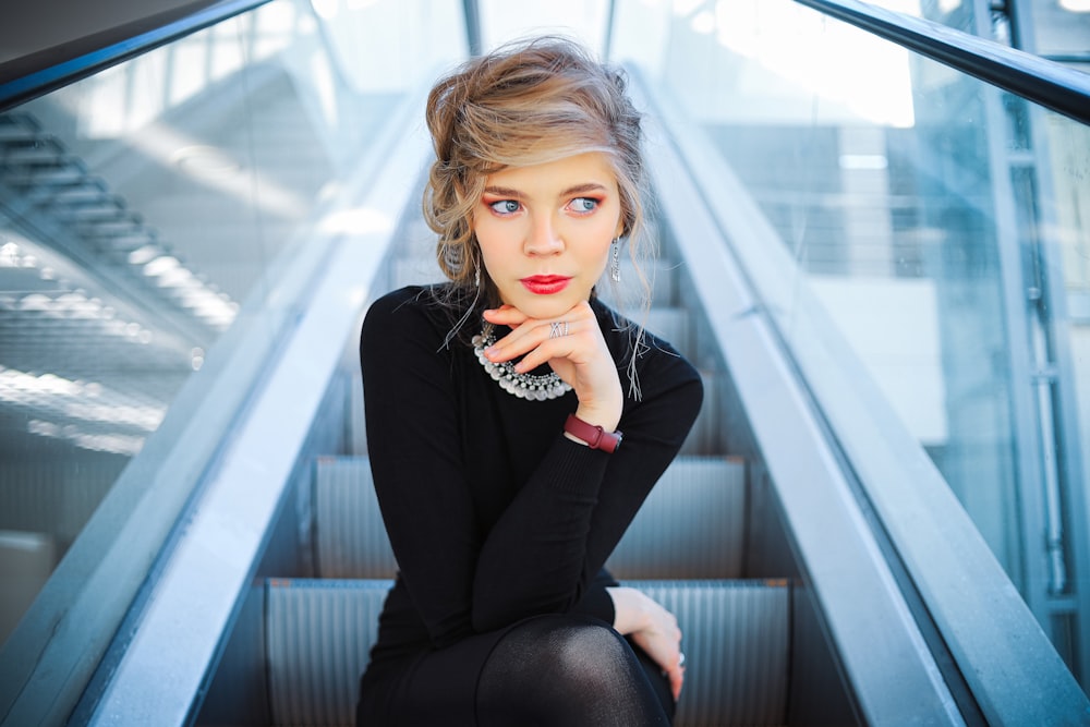 woman in black long sleeve shirt sitting on stairs