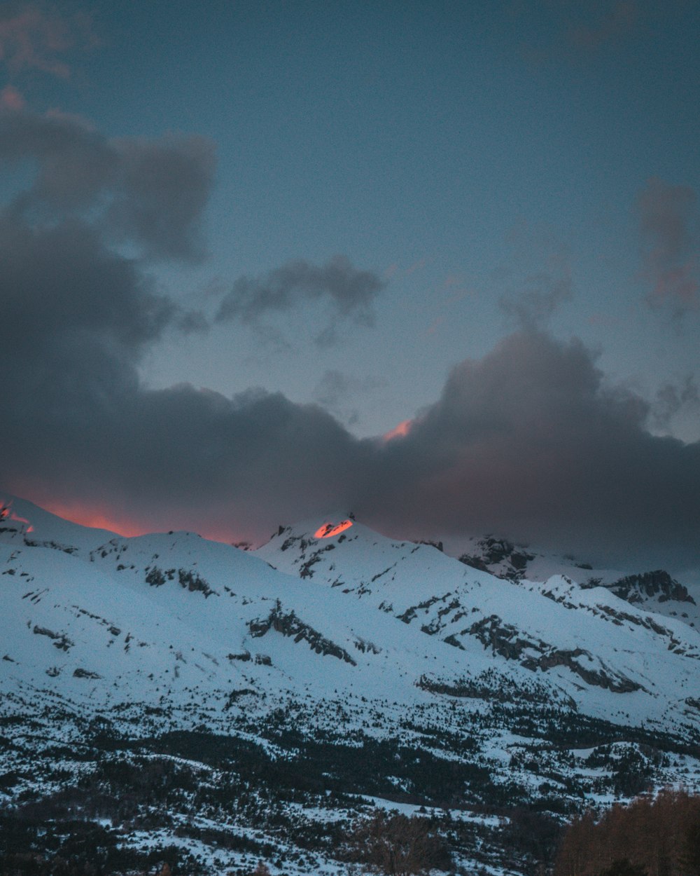 snow covered mountain under cloudy sky during daytime