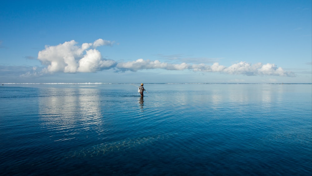 pessoa no corpo de água sob o céu azul durante o dia