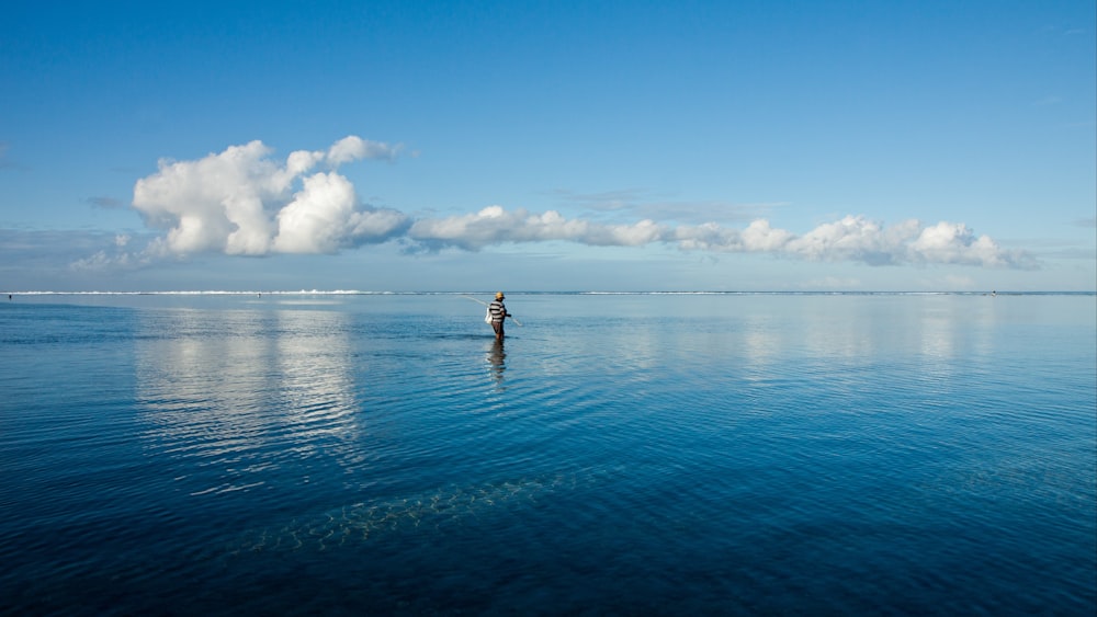 person in body of water under blue sky during daytime