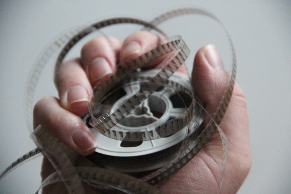 person holding silver and black round accessory