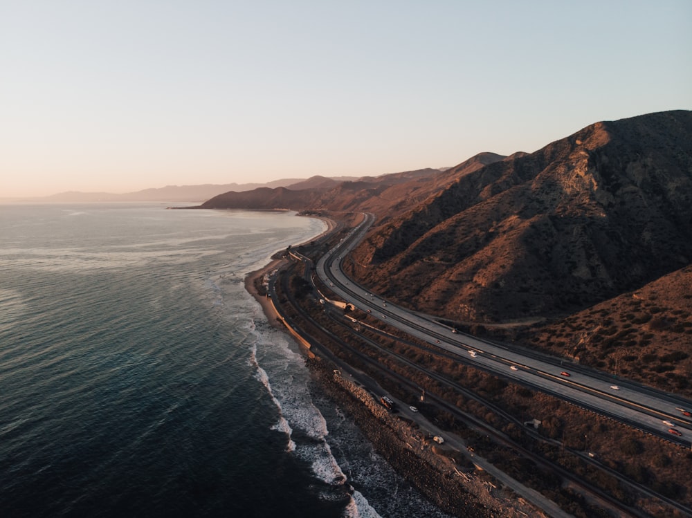 black asphalt road near body of water during daytime