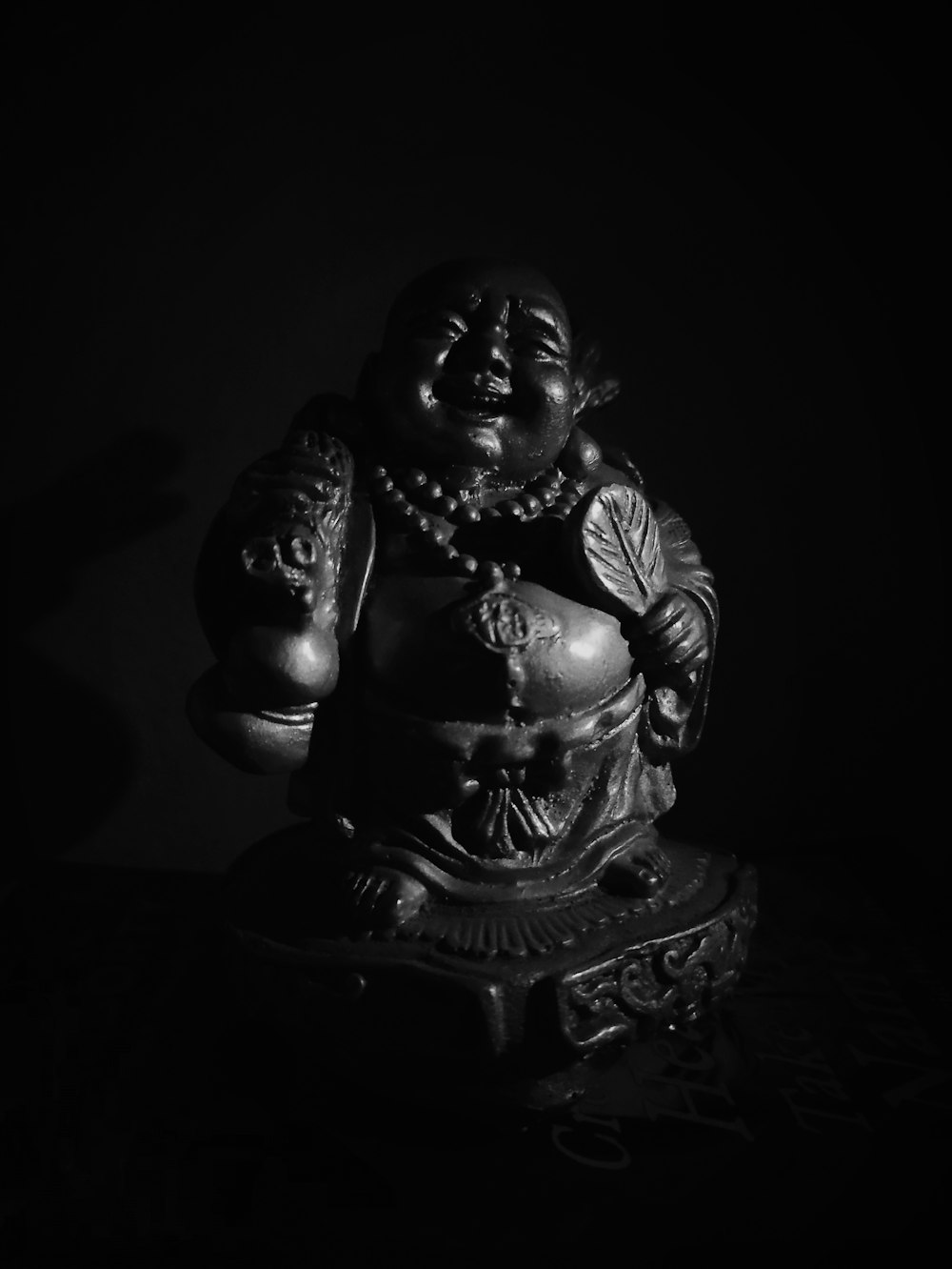 grayscale photo of woman sitting figurine