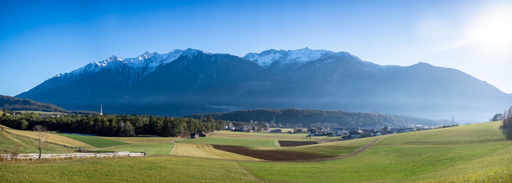 green grass field near green trees and mountain during daytime