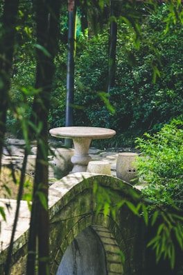 A tranquil outdoor meditation space surrounded by lush greenery and stone textures.