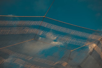 A colorful masonry grid featuring mosquito nets in fresh light blue, highlighting the airy, protective design.