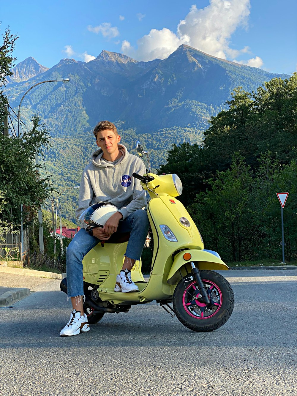 man in gray hoodie sitting on yellow motorcycle during daytime