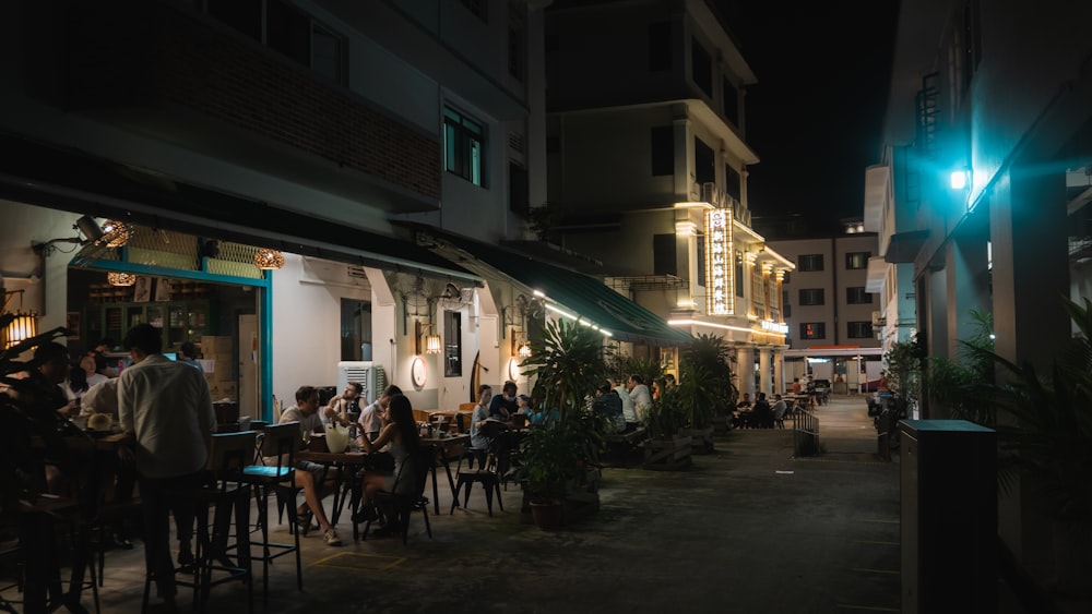 people sitting on chairs near building during night time