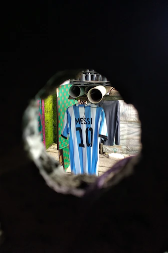 Close-up of a classic Argentina national team jersey hanging on a wooden hanger.