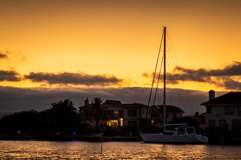 white boat on body of water during sunset