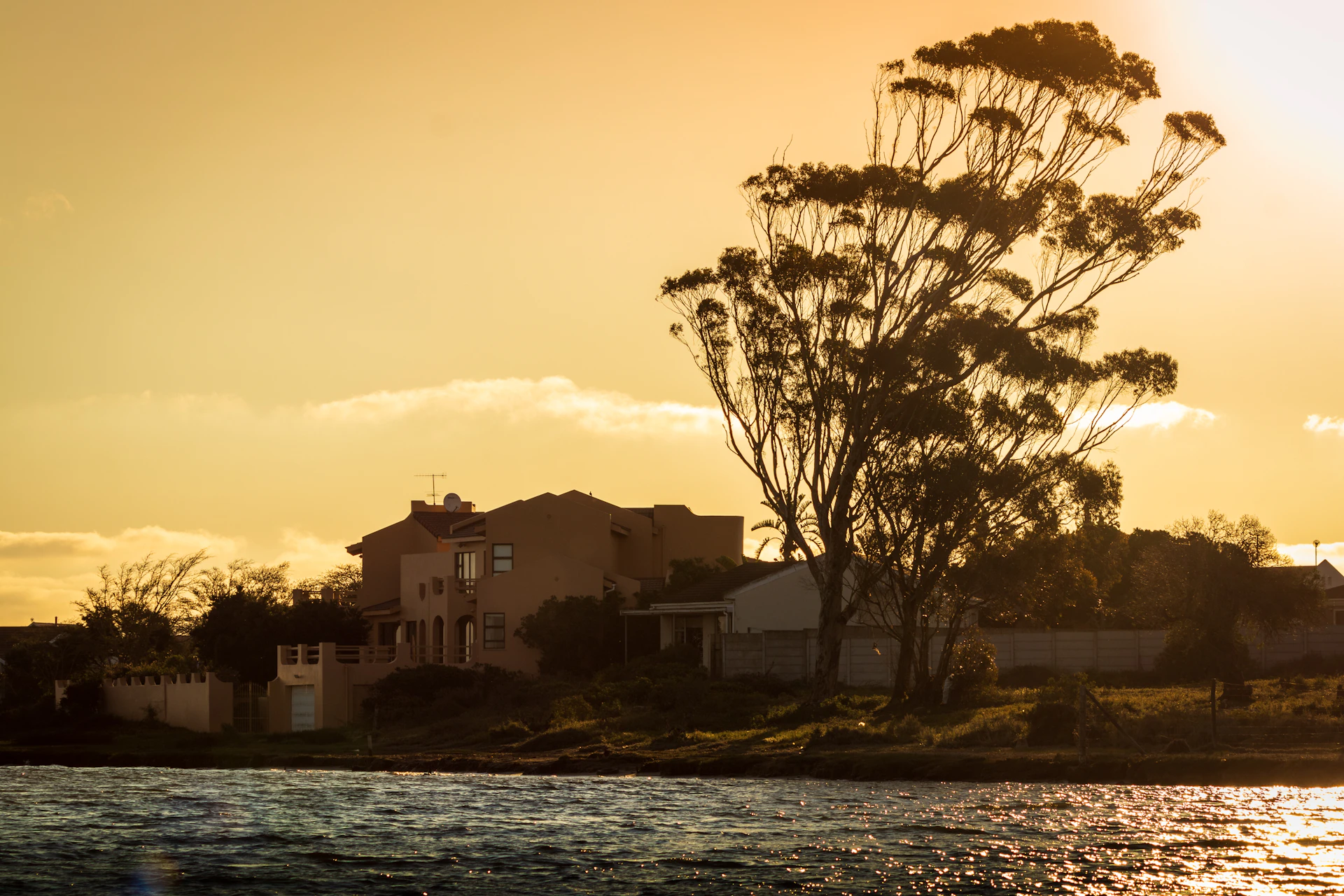 white and brown concrete building near body of water during sunset