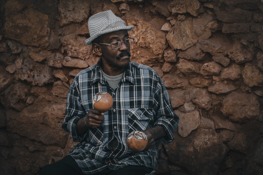 man in black and white plaid dress shirt holding brown round fruit