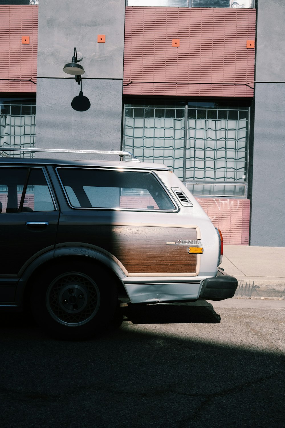 brown station wagon parked beside red and white building