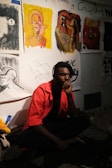 man in orange polo shirt sitting on floor