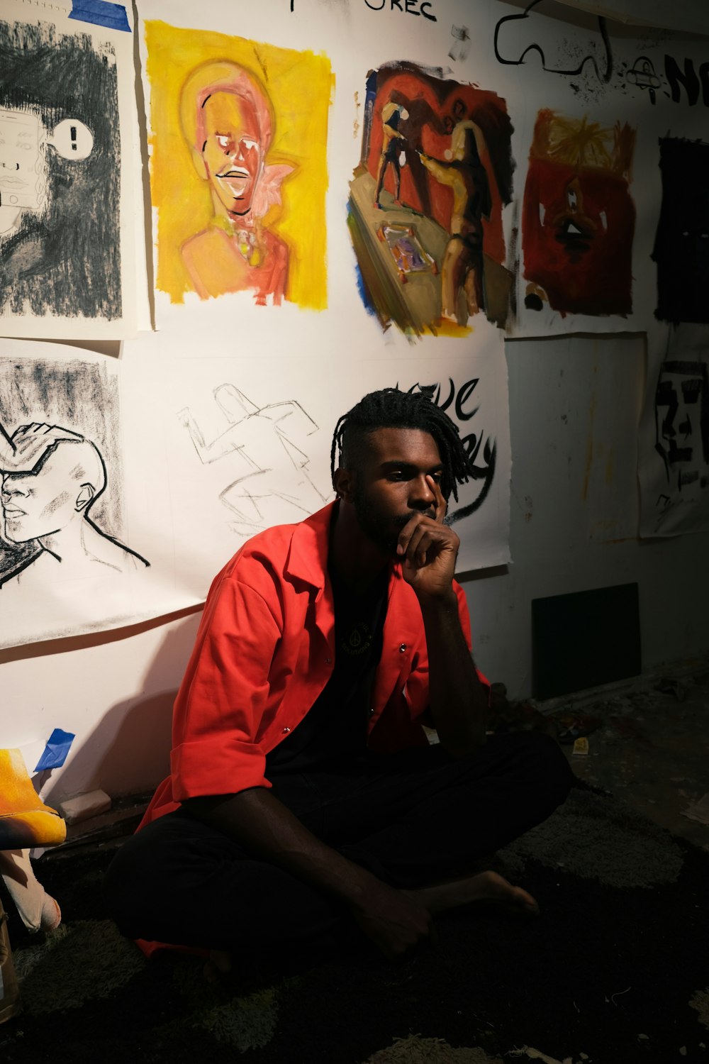 man in orange polo shirt sitting on floor