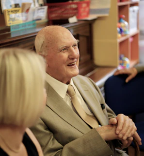 A friendly Vitalis agent warmly greeting a senior client during a consultation.