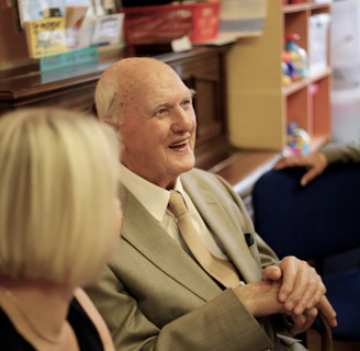 A friendly Vitalis agent warmly greeting a senior client during a consultation.