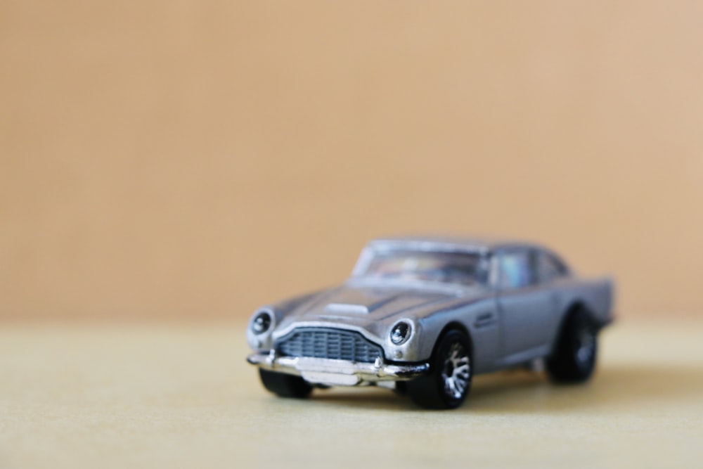 grey coupe scale model on white surface