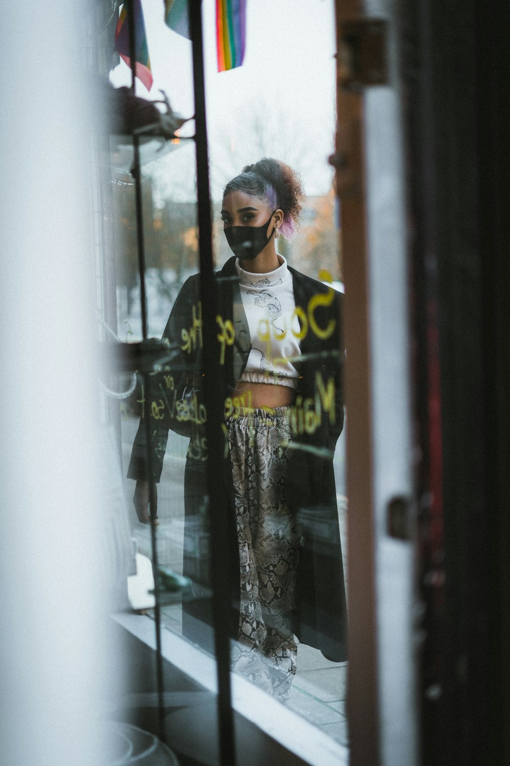 woman in black and white dress standing beside glass window