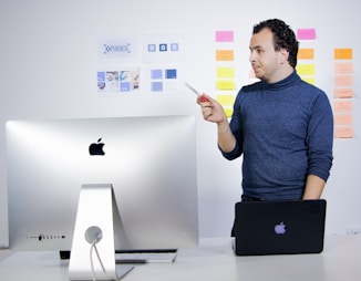 man in blue crew neck t-shirt holding black laptop computer