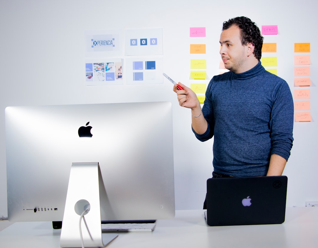 man in blue crew neck t-shirt holding black laptop computer, Brainstorming