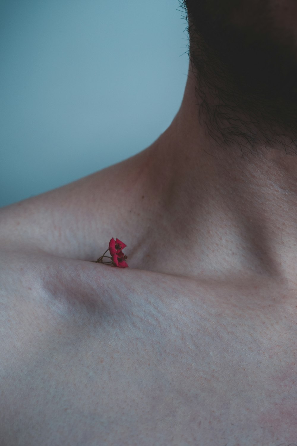 red plastic hair clip on mans chest