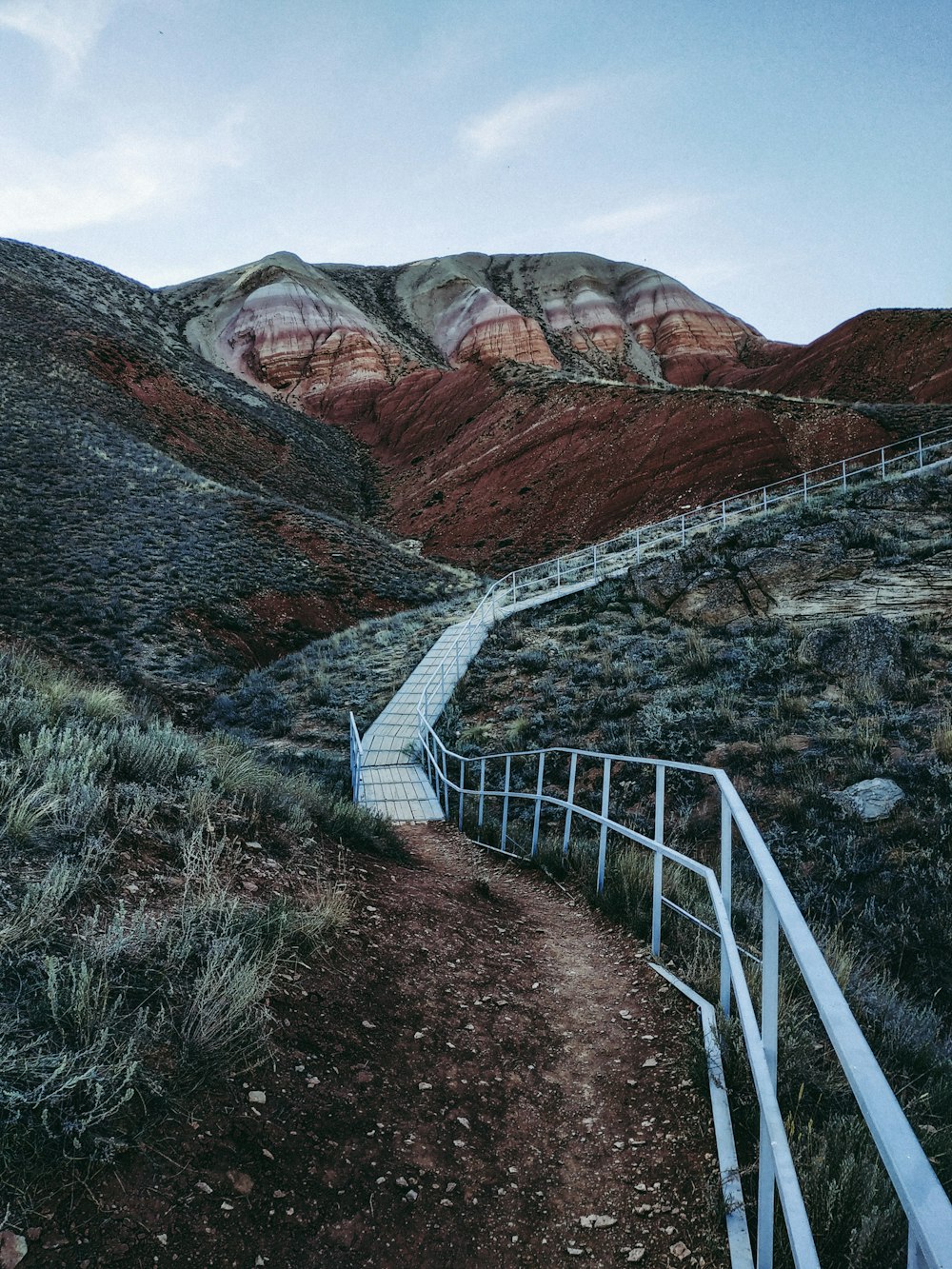 a path leading up to a hill with a mountain in the background