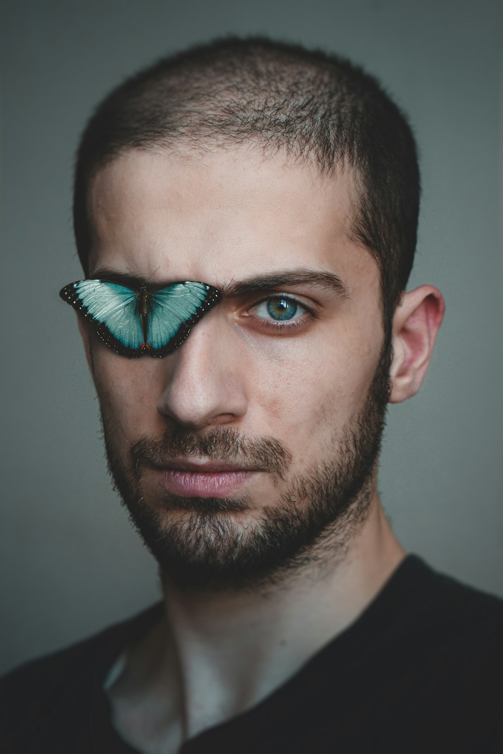 man in black crew neck shirt with green and blue eye shadow