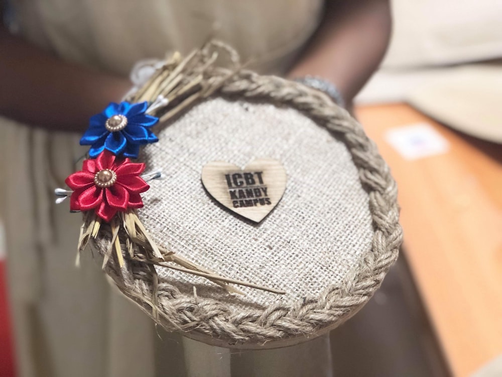 person holding brown and white woven round basket