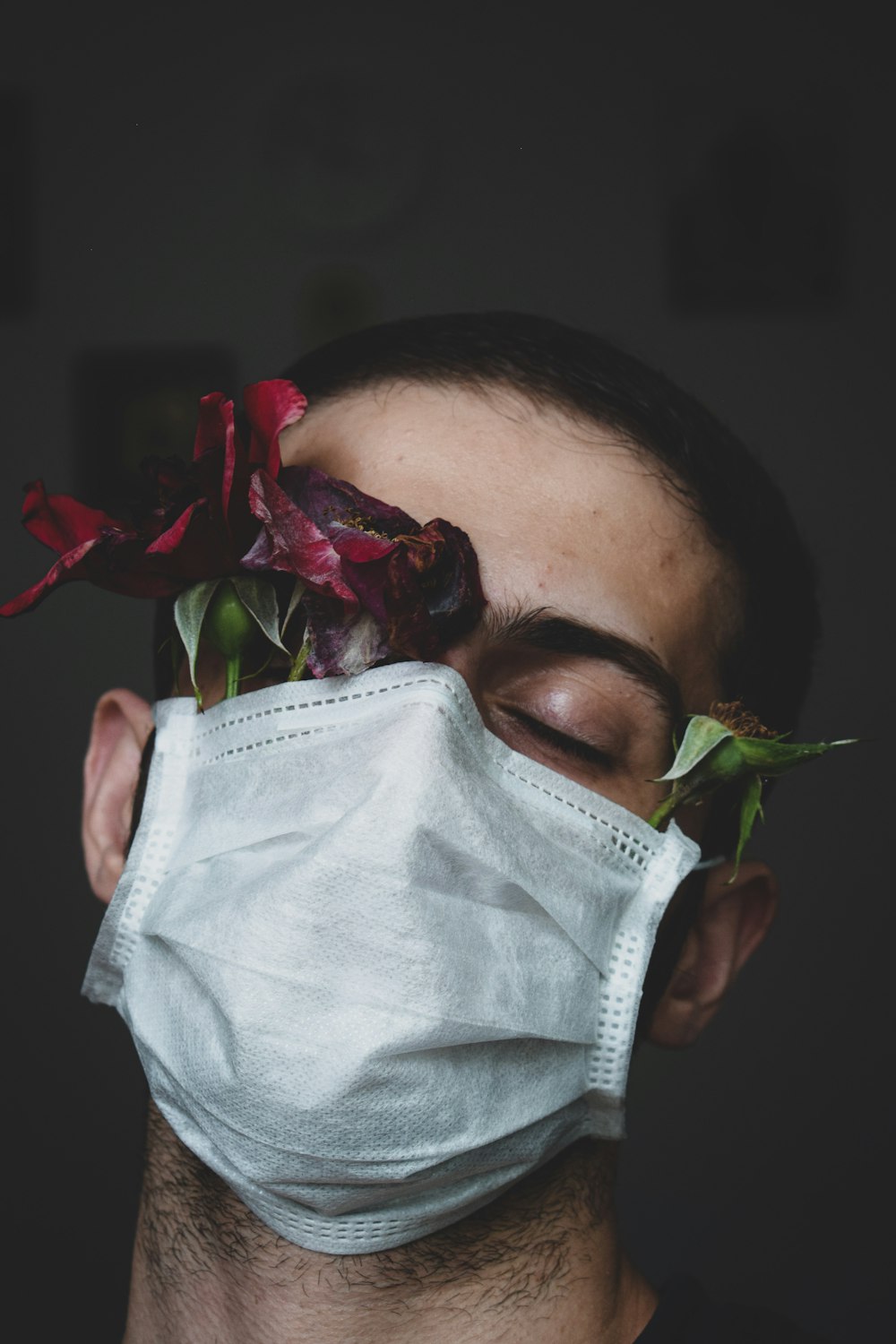 woman in white face mask holding red rose