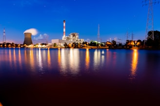 city skyline across body of water during night time