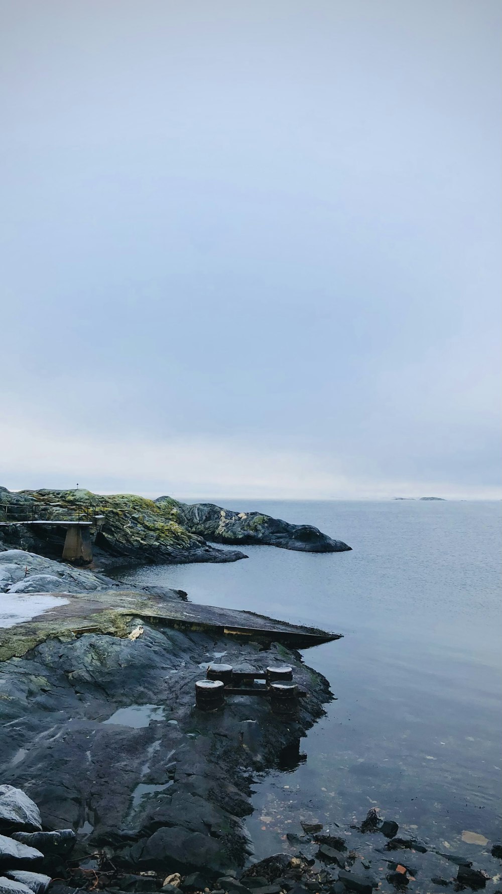 gray and green rock formation near body of water during daytime