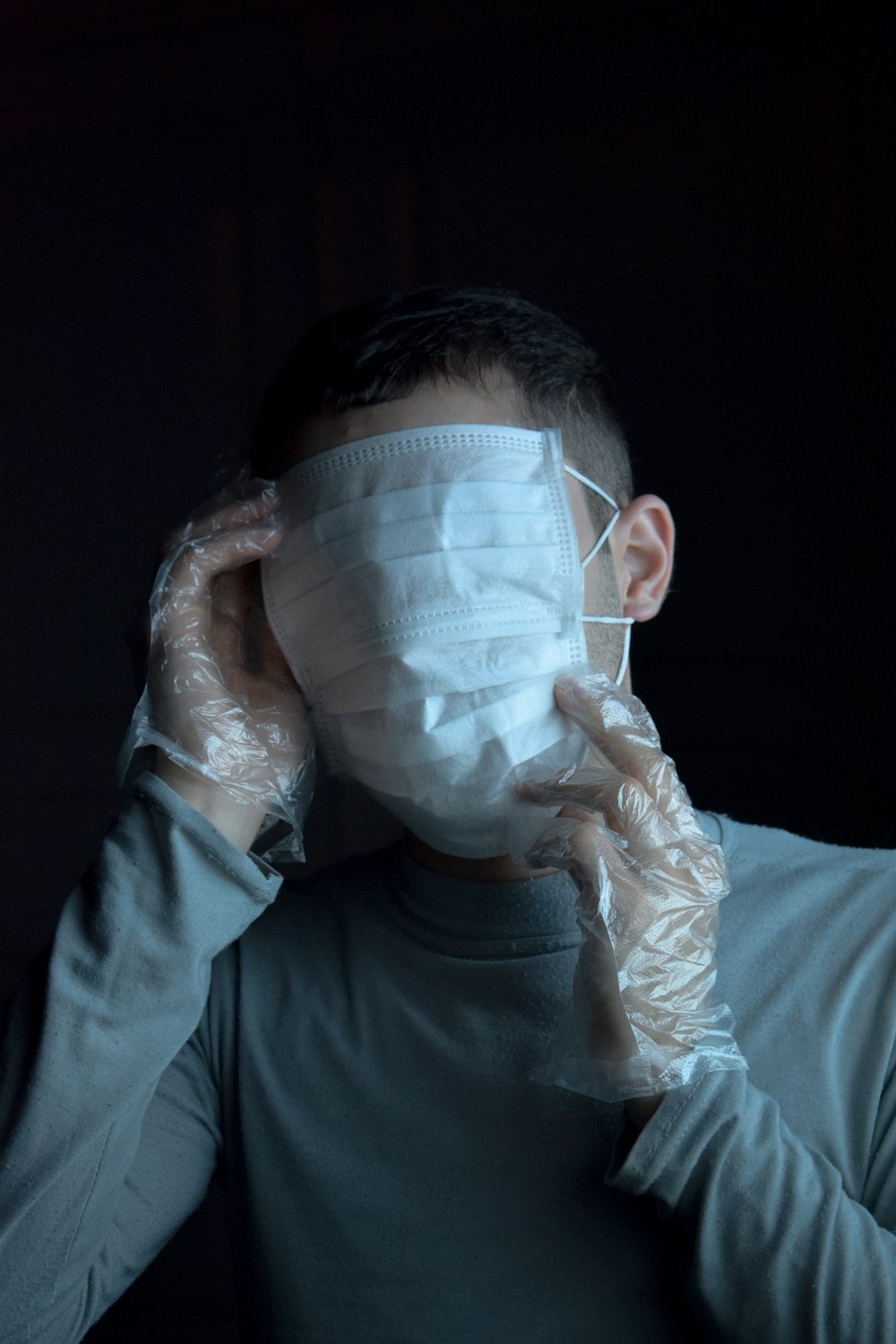 man in gray long sleeve shirt covering face with white textile