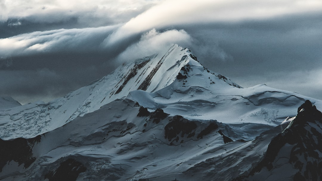 snow covered mountain under white clouds