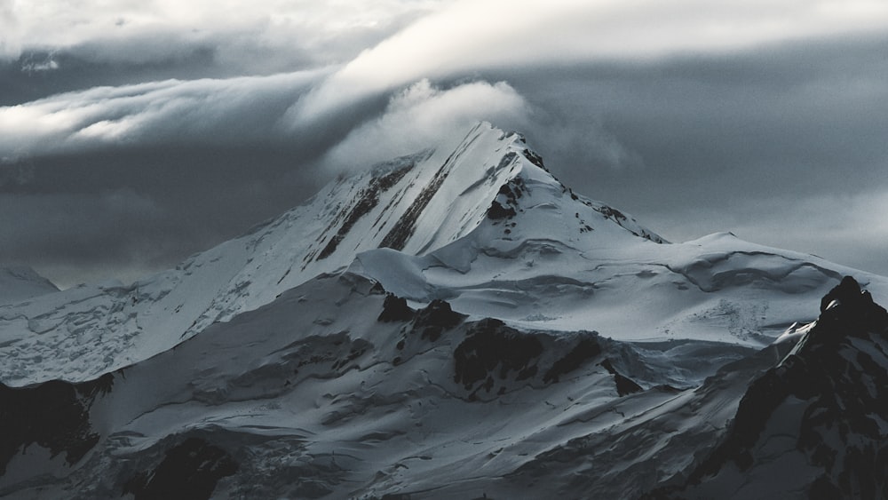 montanha coberta de neve sob nuvens brancas