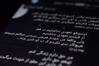 The image displays text on a digital screen with black background. The text is written in Persian and white font. The time 12:11 PM and an indication of editing are visible.