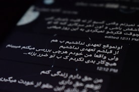 The image displays text on a digital screen with black background. The text is written in Persian and white font. The time 12:11 PM and an indication of editing are visible.